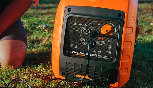 A portable generator powering up with cables plugged in, against an outdoor backdrop, indicating readiness for use during camping or a power outage.