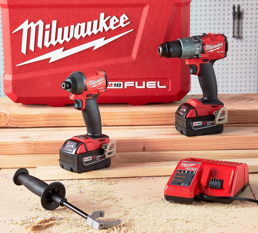 A collection of the top 3 Milwaukee combo kits, including a hammer drill and impact driver, with batteries, a charger, and a branded carrying case, displayed on a wooden surface with sawdust